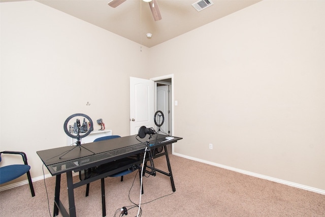 carpeted home office with high vaulted ceiling and ceiling fan