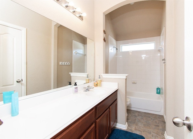 full bathroom featuring tiled shower / bath combo, vanity, and toilet