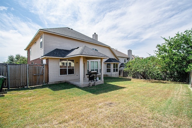 back of house featuring a yard and a patio area