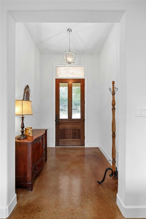 entrance foyer featuring concrete flooring and a notable chandelier