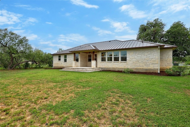 1323 Hi Cir N, Horseshoe Bay, TX 78657 - rear view of property featuring stone siding, a yard, a standing seam roof, and metal roof