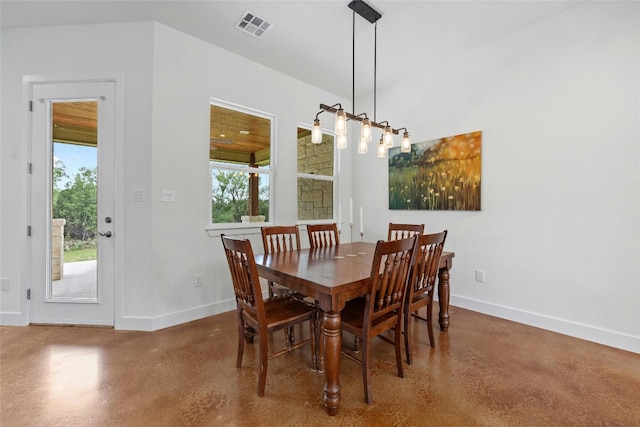 dining room with an inviting chandelier and concrete floors