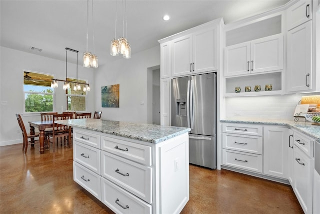 kitchen with white cabinets, pendant lighting, stainless steel fridge, tasteful backsplash, and a center island