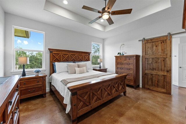1323 Hi Cir N, Horseshoe Bay, TX 78657 - bedroom featuring concrete floors, a tray ceiling, recessed lighting, a barn door, and ceiling fan