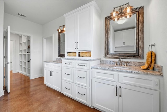 1323 Hi Cir N, Horseshoe Bay, TX 78657 - bathroom featuring vanity, finished concrete floors, baseboards, and a spacious closet