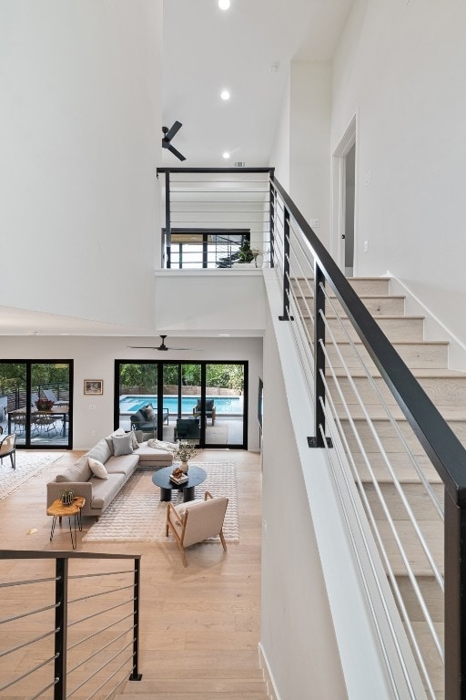 living room with light hardwood / wood-style flooring and a towering ceiling