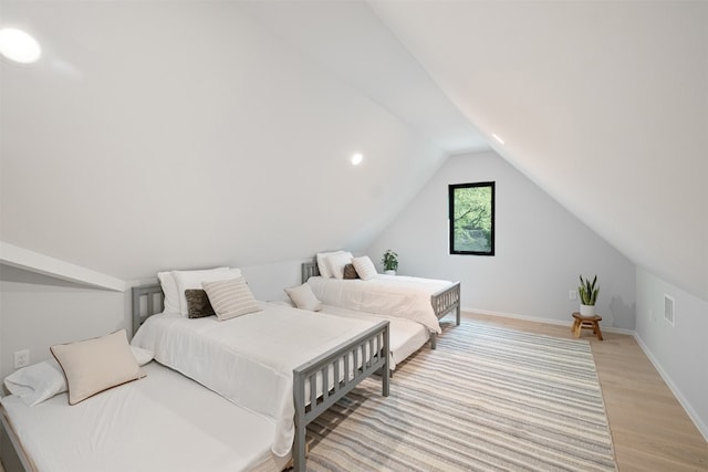 bedroom with light hardwood / wood-style flooring and lofted ceiling