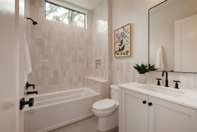 full bathroom featuring tile patterned floors, vanity, tile walls, toilet, and tiled shower / bath