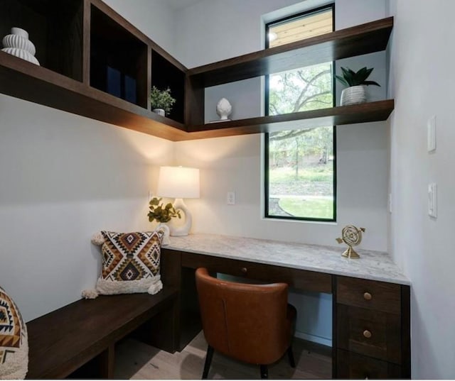 office area with built in desk and light hardwood / wood-style flooring