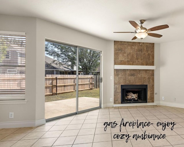 tiled living room featuring a tiled fireplace, baseboards, and ceiling fan