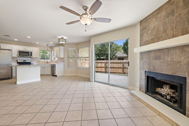 110 Dogwood Dr, Georgetown, TX 78626 - unfurnished living room with a fireplace, recessed lighting, a ceiling fan, visible vents, and a sink