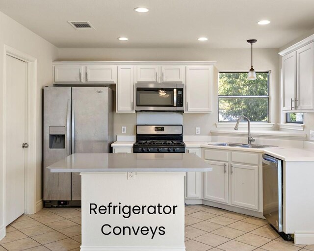 kitchen featuring stainless steel appliances, sink, decorative light fixtures, white cabinets, and a center island