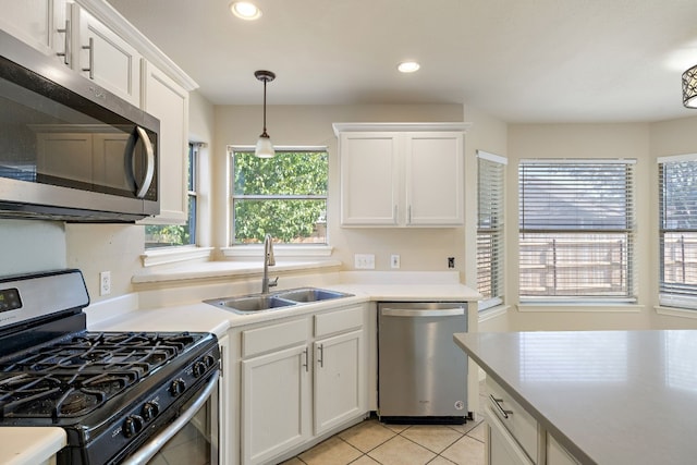 kitchen featuring a sink, stainless steel appliances, white cabinets, and light countertops