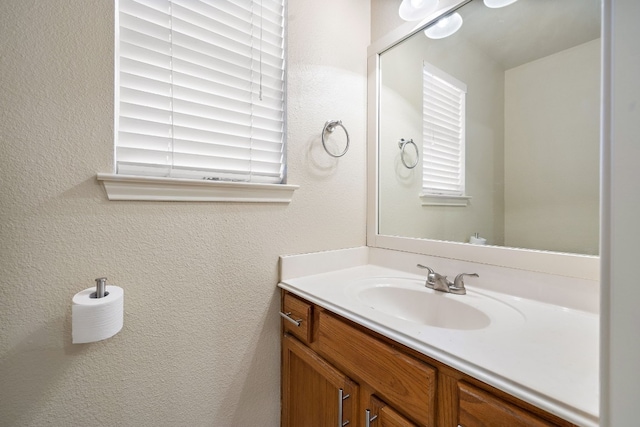 bathroom with vanity and a textured wall