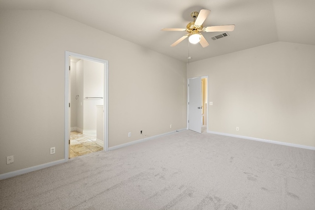 unfurnished bedroom featuring ceiling fan, light colored carpet, a spacious closet, and vaulted ceiling