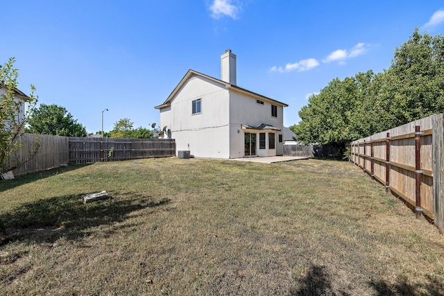 rear view of property with central air condition unit, a patio, and a yard