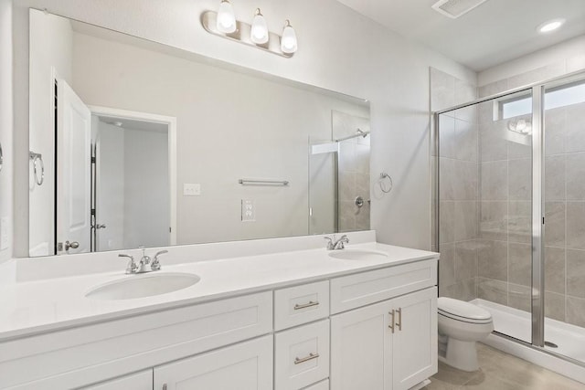 bathroom featuring vanity, toilet, and a shower with door