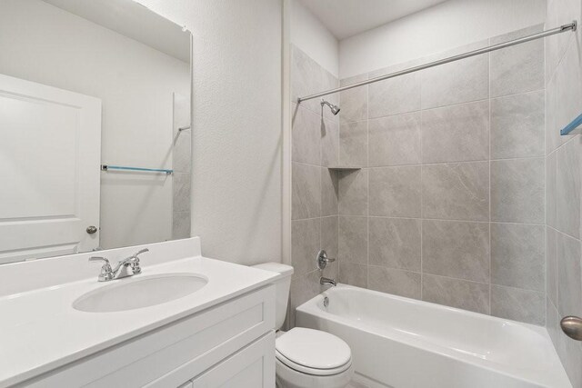 full bathroom featuring vanity, toilet, and tiled shower / bath