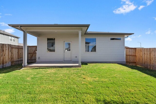 back of property with a yard and a patio