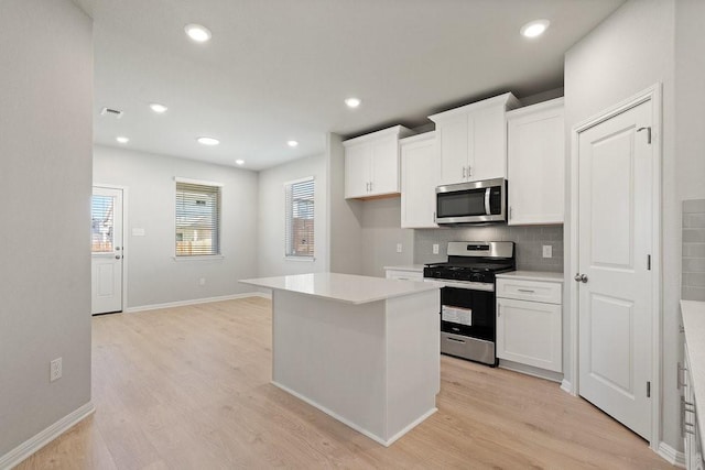 kitchen featuring white cabinetry, a kitchen island, light hardwood / wood-style floors, and appliances with stainless steel finishes