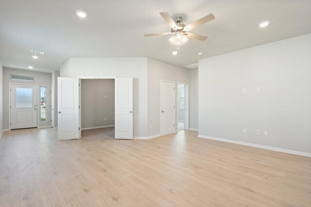 unfurnished living room with ceiling fan and light wood-type flooring