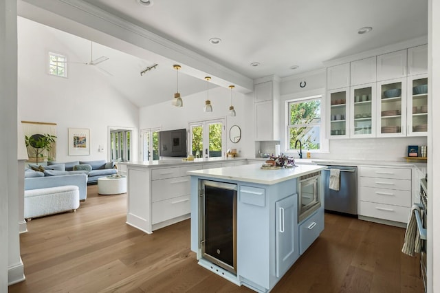 kitchen featuring a kitchen island, wine cooler, pendant lighting, white cabinetry, and appliances with stainless steel finishes