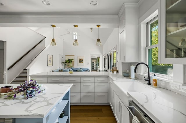 kitchen featuring sink, white cabinetry, light stone counters, hanging light fixtures, and dark hardwood / wood-style floors