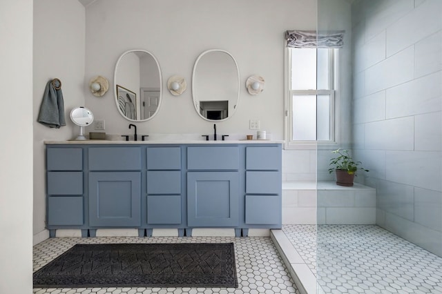 bathroom featuring tile patterned floors, a sink, a walk in shower, and double vanity