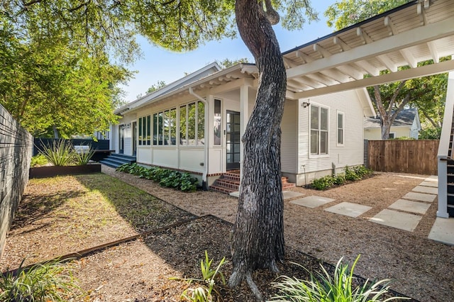 view of home's exterior with fence and entry steps