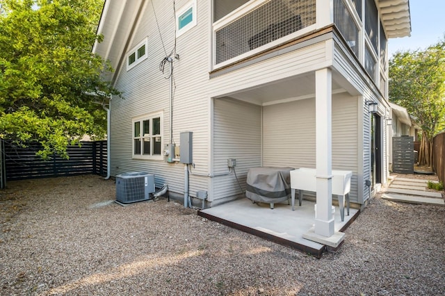 rear view of house featuring fence, central AC, and a patio