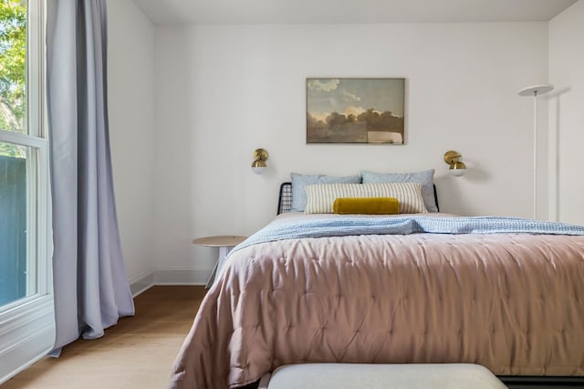 bedroom with wood finished floors and baseboards