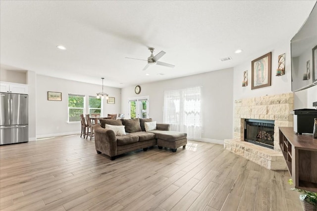 113 Tonkawa Ln, Paige, TX 78659 - living room with ceiling fan, light wood-style floors, a fireplace with raised hearth, baseboards, and recessed lighting