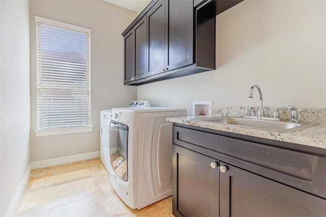 laundry area featuring washing machine and clothes dryer, light tile patterned floors, cabinet space, a sink, and baseboards