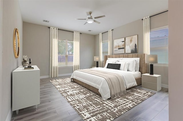 bedroom with baseboards, a ceiling fan, visible vents, and wood tiled floor