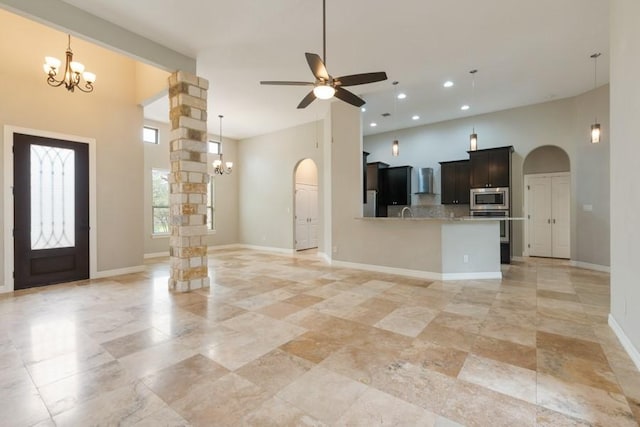 foyer entrance featuring arched walkways, recessed lighting, ceiling fan with notable chandelier, and baseboards