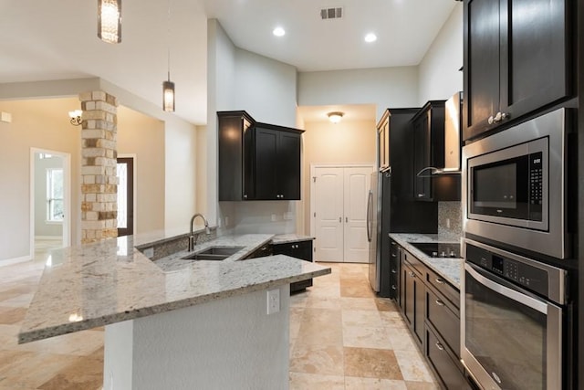 kitchen featuring decorative columns, visible vents, appliances with stainless steel finishes, a sink, and dark cabinetry