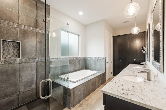 full bath featuring a stall shower, double vanity, a sink, and a bath