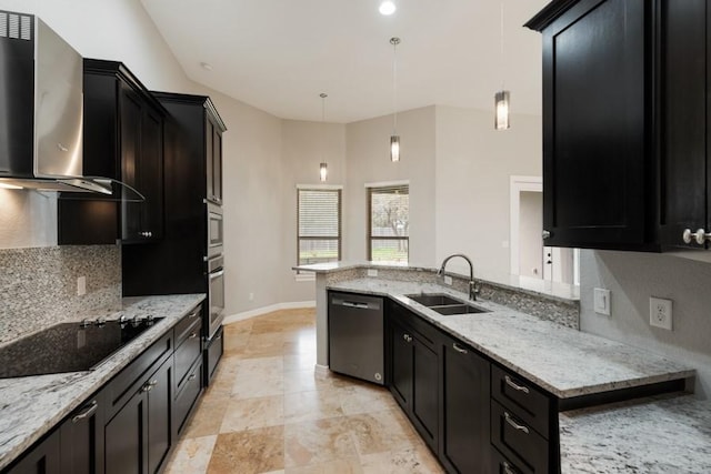 kitchen with light stone counters, stainless steel appliances, a sink, wall chimney exhaust hood, and tasteful backsplash