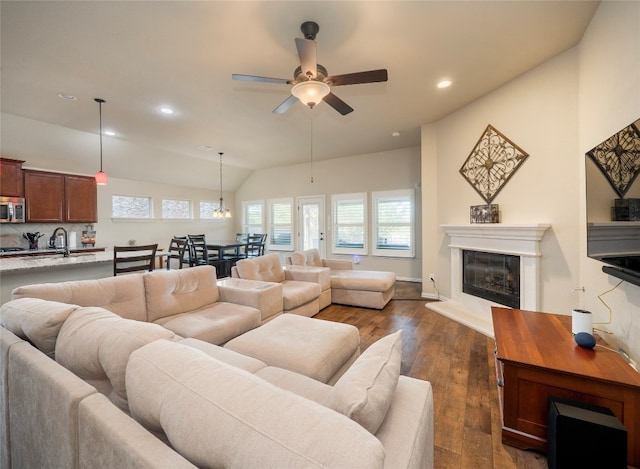 living room featuring ceiling fan, sink, dark hardwood / wood-style floors, and vaulted ceiling