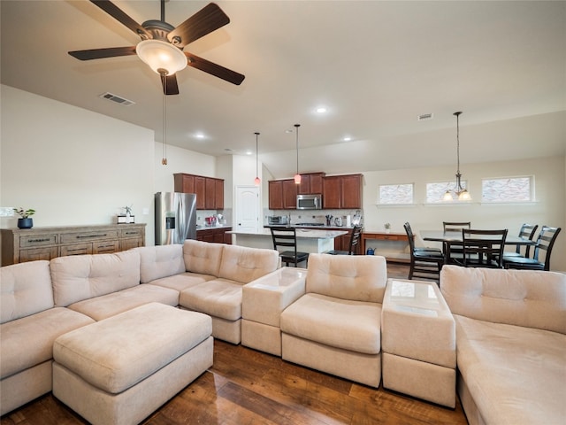 living room featuring dark wood-type flooring and ceiling fan