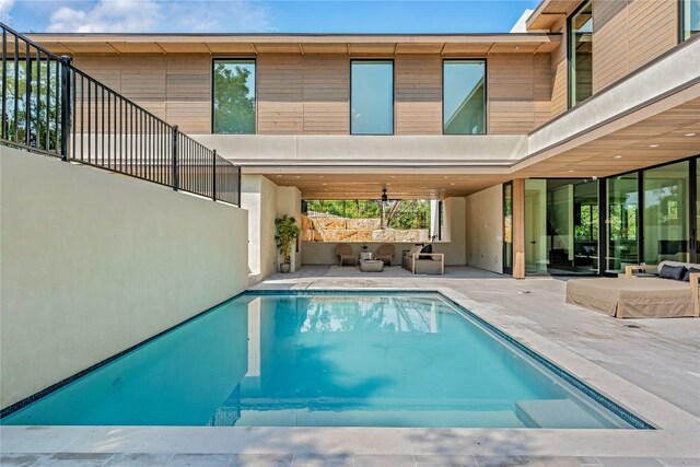 view of swimming pool featuring a patio, an outdoor living space, and ceiling fan