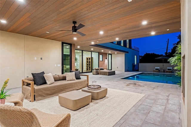 view of swimming pool featuring a patio, an outdoor living space with a fire pit, and ceiling fan