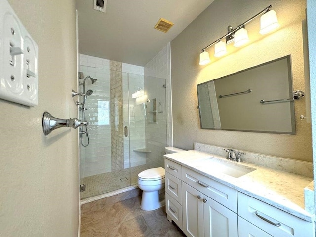 bathroom with tile patterned floors, an enclosed shower, vanity, and toilet