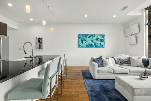 living area with dark wood-style floors, recessed lighting, visible vents, and baseboards