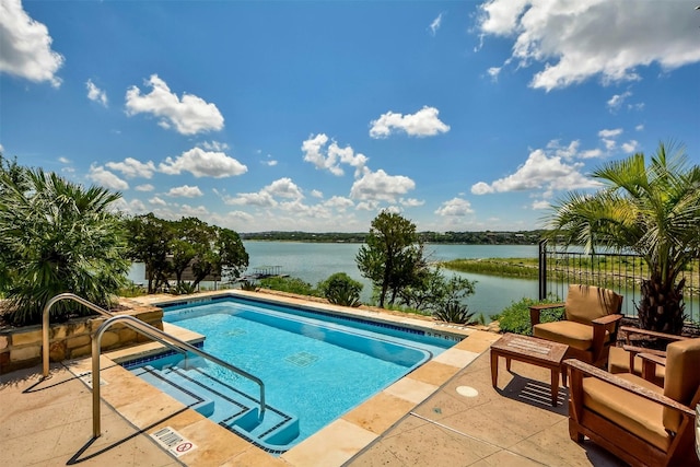 view of swimming pool featuring a patio and a water view