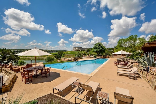 view of swimming pool with a patio and a water view