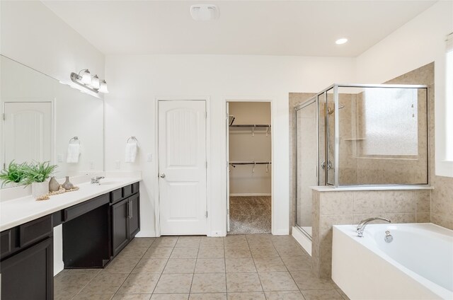 bathroom featuring shower with separate bathtub, tile patterned floors, and vanity