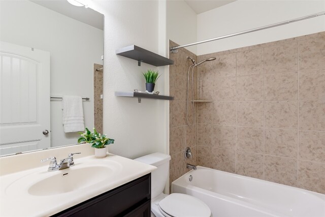 full bathroom with toilet, vanity, and tiled shower / bath