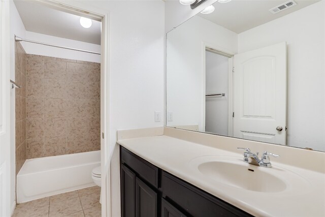 full bathroom with vanity, tile patterned floors, toilet, and tiled shower / bath