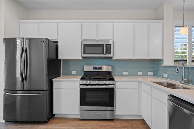 kitchen with white cabinets, stainless steel appliances, light wood-type flooring, and sink